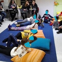 Invito da parte del conduttore ad accomodarsi (i bambini in genere si mettono sul tappeto, mentre gli adulti preferiscono accomodarsi sulle sedie)